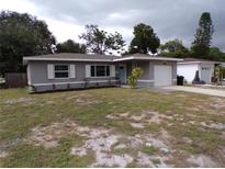 Updated one-story home with gray exterior, landscaped lawn, and attached garage at 895 64Th S Ave, St Petersburg, FL 33705