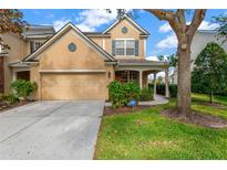 Two-story house with tan siding, two-car garage, and landscaped lawn at 10112 Haverhill Ridge Dr, Riverview, FL 33578