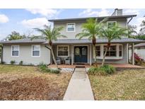 Two-story house with gray siding, palm trees, and a walkway at 1534 Wexford N Dr, Palm Harbor, FL 34683