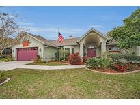 Single-story house with landscaped yard, attached garage, and a walkway at 1728 Allens Ridge N Dr, Palm Harbor, FL 34683