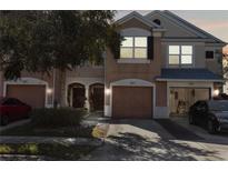 Two-story townhome with attached garage and landscaping at 26614 Castleview Way, Wesley Chapel, FL 33544