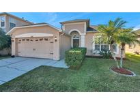 Attractive single-story home with a two-car garage and well-manicured lawn at 4506 Mapletree Loop, Wesley Chapel, FL 33544