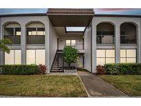 Two-story building exterior with walkway and landscaping at 7701 Starkey Rd # 105, Seminole, FL 33777