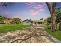 Newly renovated home with a large driveway and landscaped lawn at 1004 Peninsula Ave, Tarpon Springs, FL 34689