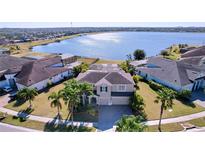 House on a lake with lush landscaping and other homes at 11525 Lake Lucaya Dr, Riverview, FL 33579