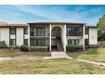 Two-story condo building with balconies and landscaped grounds at 1882 Pine Ridge W Way # E1, Palm Harbor, FL 34684