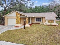 Updated single-story home with stone accents and a landscaped lawn at 2715 Narcissus Dr, Holiday, FL 34691