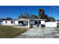 Ranch-style home with a covered porch, landscaped yard, and solar panels at 2801 Auburn W Ave, Tampa, FL 33614