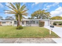 Newly renovated single story home with a landscaped lawn and driveway at 3405 Nixon Rd, Holiday, FL 34691