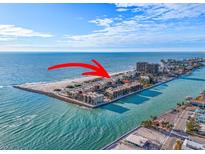 Aerial view of beachfront condo building with ocean and beach access at 7466 Bayshore Dr # 406, Treasure Island, FL 33706