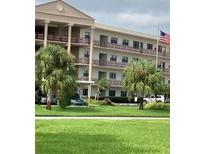 Two-story condo building with palm trees and green lawn at 7975 58Th N Ave # 402, St Petersburg, FL 33709