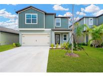 Two-story house with a light teal exterior, attached garage, and a well-manicured lawn at 12554 Timber Moss Ln, Riverview, FL 33579