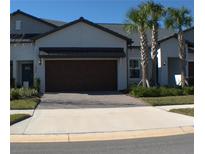 Two-story house with brown garage door and landscaped yard at 16843 Forge Surf St, Land O Lakes, FL 34638