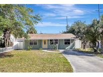 Charming light green house with a well-maintained lawn and a paved driveway at 5211 2Nd S Ave, St Petersburg, FL 33707