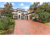 Luxury two-story home with brick driveway, lush landscaping, and three-car garage at 4902 Carranza Ct, Tampa, FL 33616