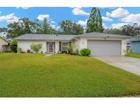 White brick ranch home with landscaped lawn, attached garage, and red front door at 520 Bryan Valley Ct, Brandon, FL 33511