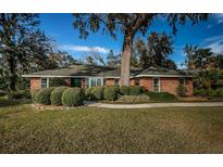 Brick ranch home with a large front yard, mature landscaping, and a spacious walkway at 118 Laurel Tree Way, Brandon, FL 33511