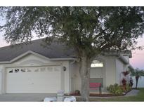 Front view of a single-story house with a two-car garage and mature landscaping at 1922 Echo Pond Pl, Wesley Chapel, FL 33543