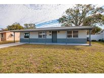 Ranch-style home with gray accents and a well-maintained lawn at 235 Se Madison N Cir, St Petersburg, FL 33703