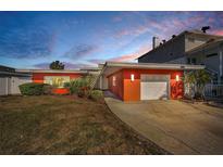 Orange mid-century modern home with a single-car garage at 366 La Hacienda Dr, Indian Rocks Beach, FL 33785