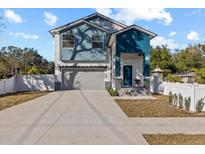 Two-story house with gray and blue exterior, white fence, and a paved driveway at 7321 Mount Vernon Rd, Tampa, FL 33625