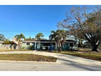 Ranch-style home with a green exterior, palm trees, and a spacious yard at 1599 Arizona Ne Ave, St Petersburg, FL 33703