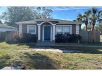 Cute bungalow home with a blue front door and well-maintained lawn at 2498 Melrose S Ave, St Petersburg, FL 33712