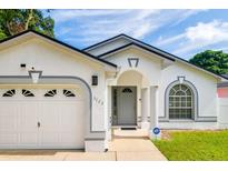 White house with gray accents, two-car garage, and a nicely landscaped front yard at 3123 W Rio Vista Ave, Tampa, FL 33614