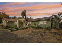Charming single-story home with lush landscaping, front yard, and a colorful sunset sky at 4829 W San Miguel St, Tampa, FL 33629