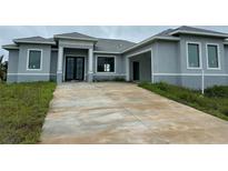 New gray house with driveway and landscaping at 10658 Rainsville St, Port Charlotte, FL 33981