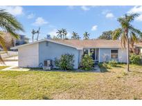 Ranch style home with blue exterior, white accents, and a landscaped yard at 5708 Bayshore Dr, Seminole, FL 33772