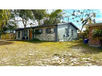 Updated exterior of house with stone accents and a small front yard at 7011 Conifer Dr, Tampa, FL 33637