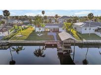 Aerial view of waterfront home with private dock and lush landscaping at 713 Gran Kaymen Way, Apollo Beach, FL 33572