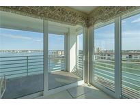 Bright condo balcony with water view, sliding glass doors and patterned valance at 7963 Sailboat Key S Blvd # 408, South Pasadena, FL 33707