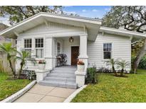 Charming white bungalow with a welcoming porch and landscaped lawn at 1301 S Gunby Ave, Tampa, FL 33606
