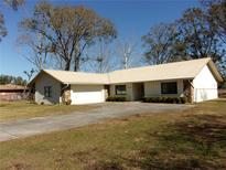 Tan metal roof ranch home with large yard and driveway at 3736 Florida Ranch Blvd, Zephyrhills, FL 33541