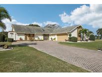 Single-story home with paved driveway, landscaping, and a two-car garage at 1928 E View Dr, Sun City Center, FL 33573