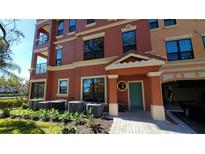 Inviting exterior of a 3-story building with teal accents, landscaping, and multiple AC units at 2757 Via Cipriani # 1114A, Clearwater, FL 33764
