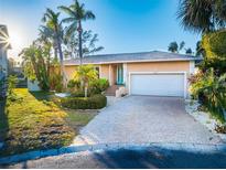 Inviting home exterior with palm trees and a brick driveway at 3998 South Cir, Largo, FL 33774