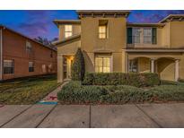 Two-story townhome with landscaping, a green door, and a sidewalk at 8729 Sheldon Creek Blvd, Tampa, FL 33615