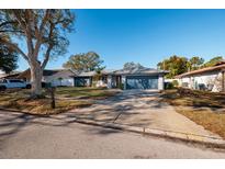 Single-story home with blue garage doors and well-maintained lawn at 9372 121St St, Seminole, FL 33772