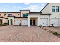 Exterior view of townhouses with attached garages and brick pavers at 10043 Crooked Creek Dr # 202, Venice, FL 34293