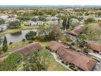 Aerial view of a community with houses near a pond at 106 Edgewood Ct, Oldsmar, FL 34677