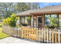 Inviting front yard with a charming white picket fence and gate at 106 Edgewood Ct, Oldsmar, FL 34677
