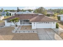 Single-story home with brown roof, white exterior, and landscaped yard at 1732 Flamingo Ln, Sun City Center, FL 33573