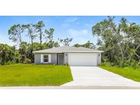 Gray house with white garage door and green lawn at 191 Prineville St, Port Charlotte, FL 33954