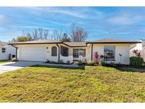 Cute ranch home with well-manicured lawn and attached garage at 2328 Pin Oak W Ln, Clearwater, FL 33759