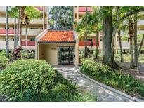Condo building entrance with landscaping and walkway at 3062 Eastland Blvd # 405, Clearwater, FL 33761
