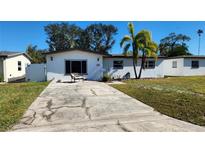 White single story house with a palm tree and driveway at 4119 Harrisburg Ne St, St Petersburg, FL 33703