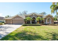 Attractive one-story home with a three-car garage and manicured lawn at 512 Creekside Ct, Safety Harbor, FL 34695